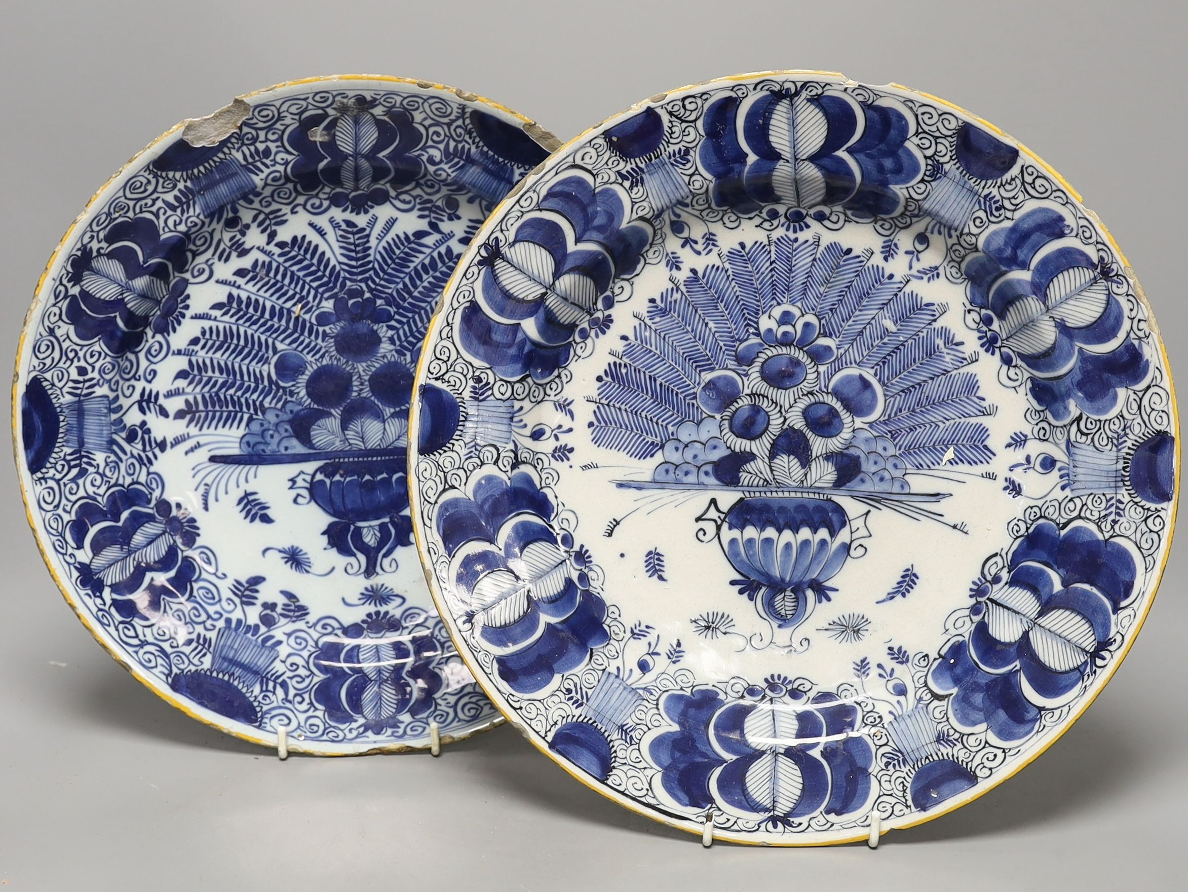 Two similar early 18th century Dutch Delft peacock pattern chargers, largest 33cms diameter.